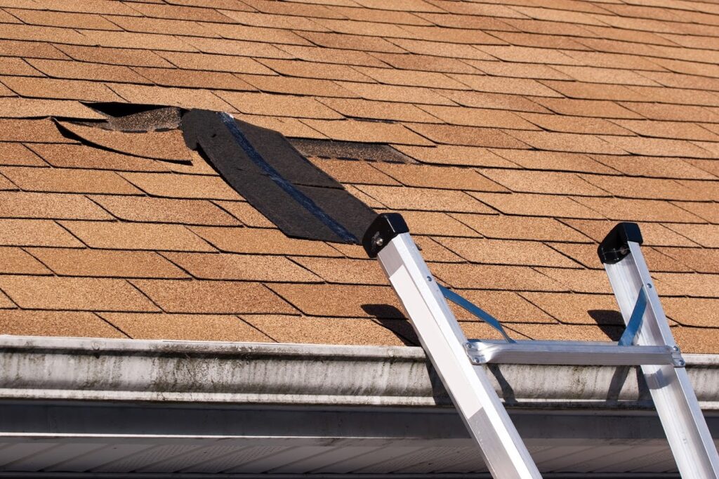 Fixing damaged roof shingles. A section was blown off after a storm with high winds causing a potential leak.